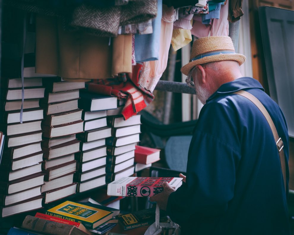 starszy mężczyzna trzymający książkę