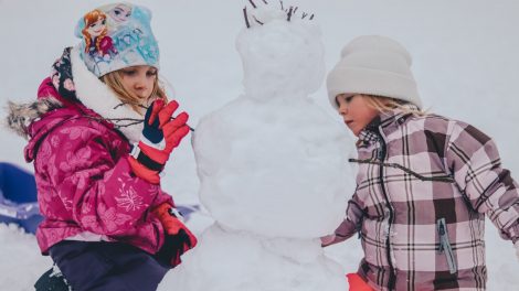 dzieci lepiące bałwana na śniegu